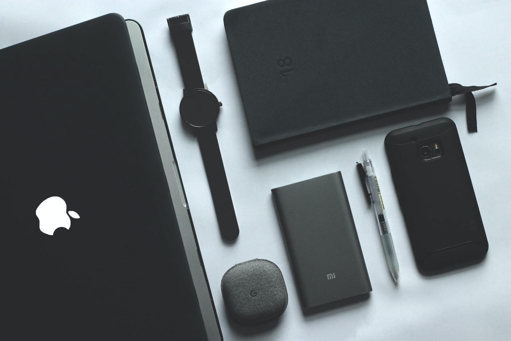Una colección de elegantes gadgets negros que incluye una tableta, un smartwatch, dos smartphones y mucho más